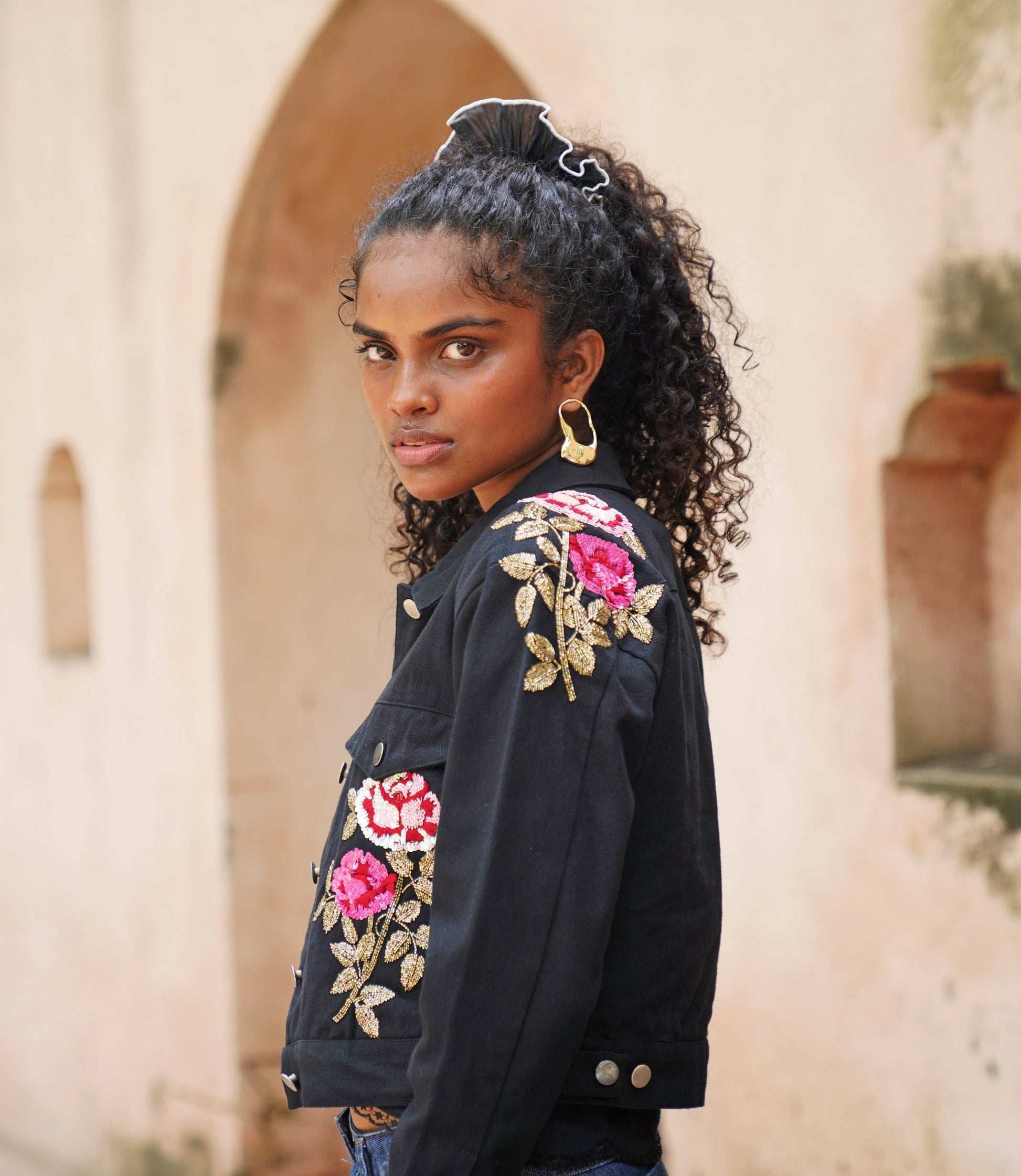 Side picture of black embroidered denim jacket