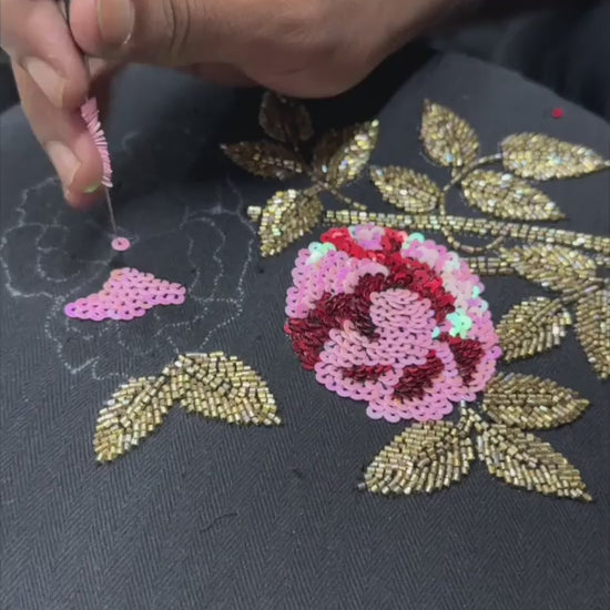 Video of artisan working on the embroidery of black embroidered denim jacket