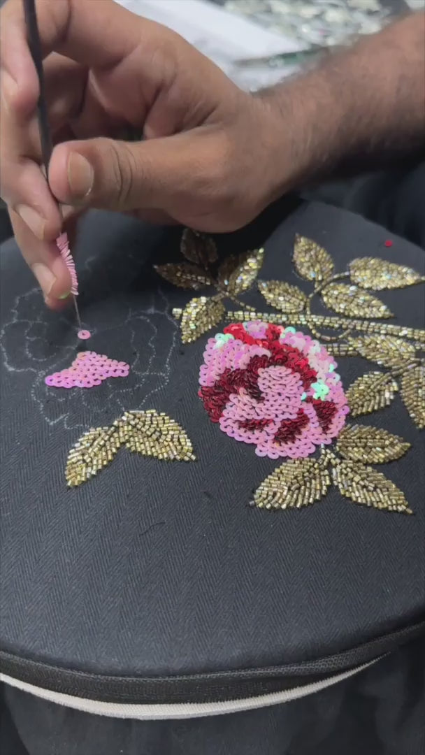 Video of artisan working on the embroidery of black embroidered denim jacket